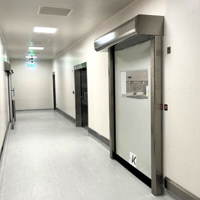 Rapidor Pharma grey self-repairing high speed door with 1 vision windows installed in a pharmaceutical factory.